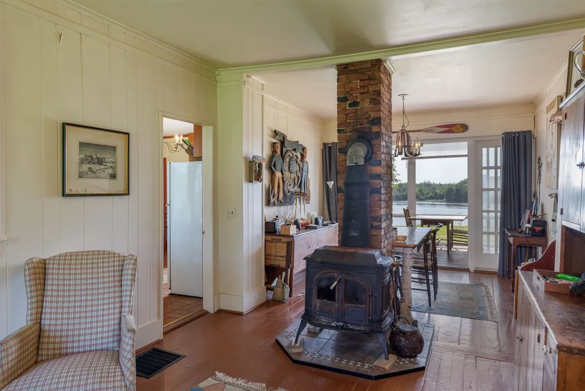 Cast-iron wood stove on brick hearth in cottage hallway