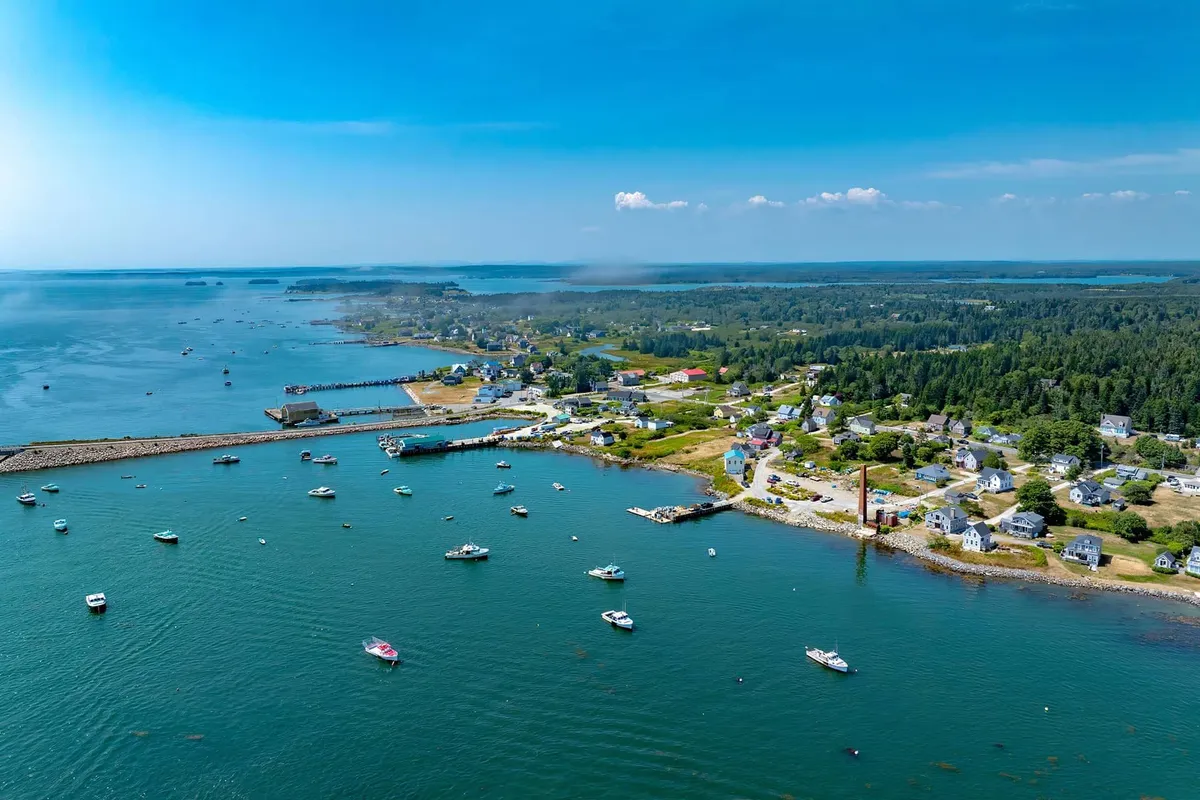Aerial view of Maine coastal harbor town with boats and blue water