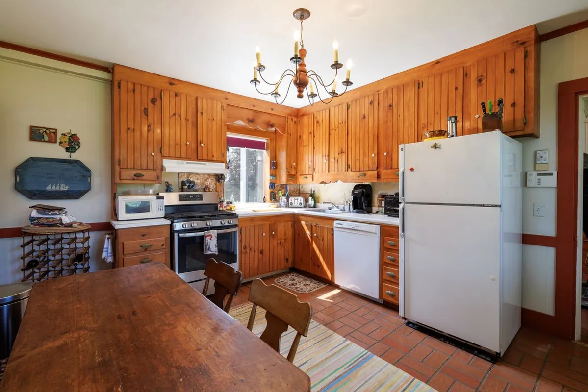 Vintage pine-paneled kitchen with chandelier and tile floor